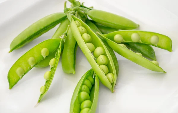 Pods of fresh green peas on a plate — Stock Photo, Image
