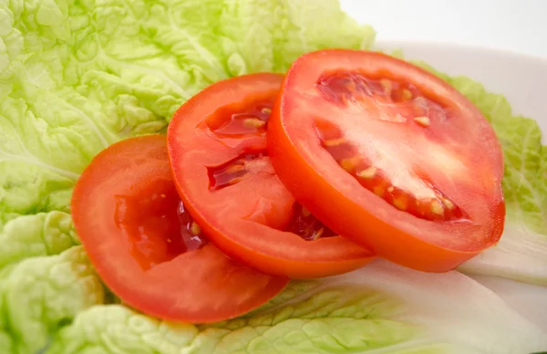 Chopped tomato slices on a piece of lettuce — Stock Photo, Image