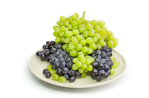 Czarny i zielony winogron kiście na białe płytki na białym tle — Zdjęcie stockowe