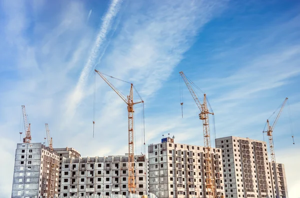 Hochhaus im Bau. Baustelle mit Kränen gegen blauen Himmel — Stockfoto