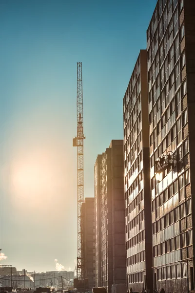 Guindastes industriais e novo edifício de vários andares — Fotografia de Stock