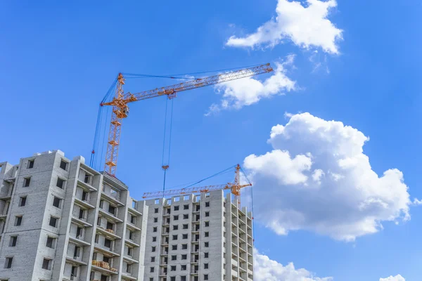 Byggandet av nya hus och hissa crane — Stockfoto
