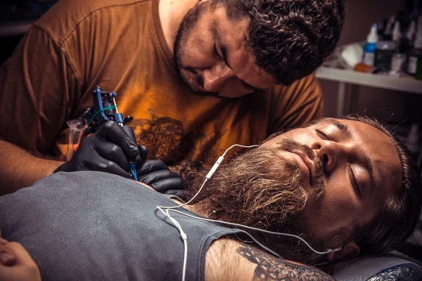 Tatuering mästaren gör tatuering i tattoo studio — Stockfoto