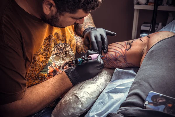 Tattooer works in tattoo studio — Stock Photo, Image