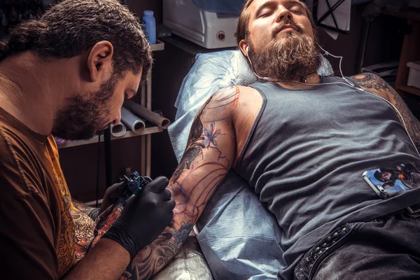 Мастер делает татуировку в студии — стоковое фото