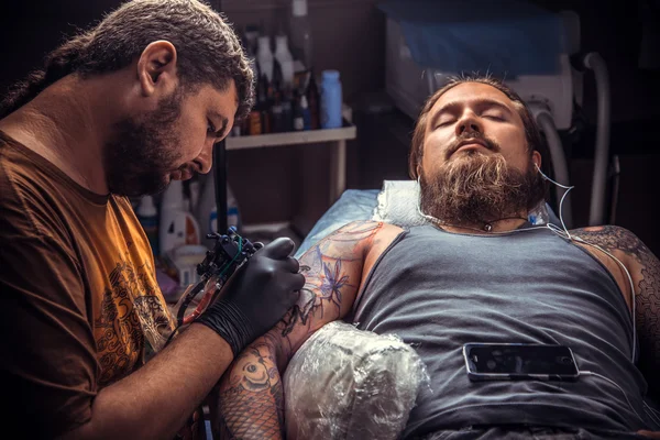 Mestre mostrando o processo de fazer uma tatuagem no estúdio de tatuagem — Fotografia de Stock