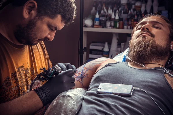 Behärska arbetande tatuera i tattoo studio — Stockfoto