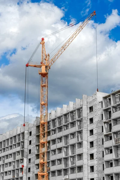 Meerdere verdiepingen huizen in aanbouw en grote kranen — Stockfoto