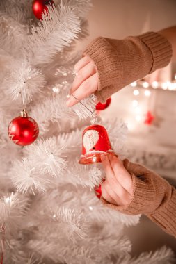 Kadın Noel ağacı süslüyor.