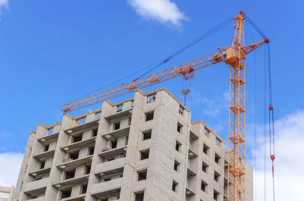 Construction of highrise houses and hoist crane — Stock Photo, Image