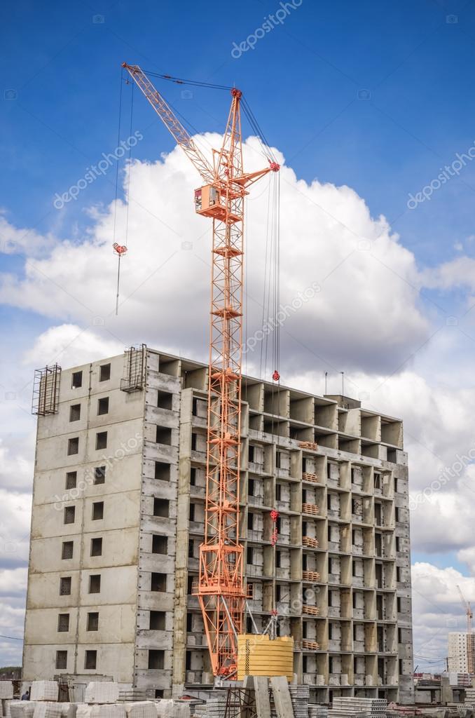 Multistorey houses under construction and lifting crane
