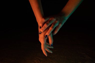 Turuncu ve yeşil neon ışıklı kadınsı eller