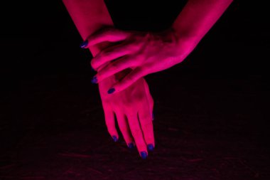 Pembe neon ışıklı kadınsı eller.