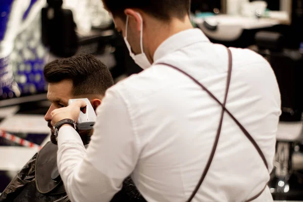 Jovem Barbeiro Costas Usa Uma Máscara Enquanto Trabalha — Fotografia de Stock