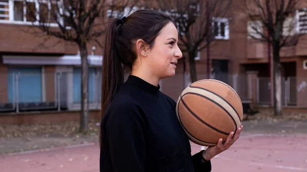 Kavkazský Basketbalista Držící Míč Ruce Obklopen Budovami — Stock fotografie