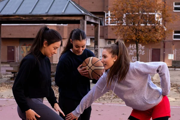 3人の若いバスケットボール選手がバスケットボールの試合前に都会のコートで笑顔 — ストック写真