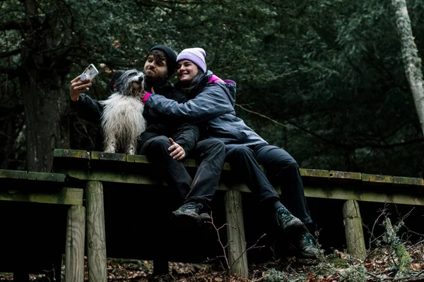 Młoda Para Siedzi Robi Sobie Selfie Drewnianej Drodze Lesie — Zdjęcie stockowe