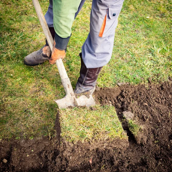 Hombre usando pala para la excavación de césped viejo — Foto de Stock