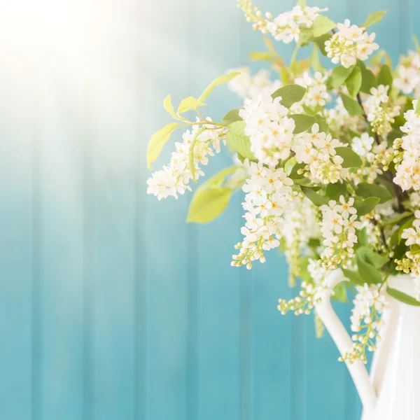 Piękne białe kwiaty w wazonie, na niebieskim tle drewniane — Zdjęcie stockowe