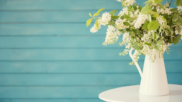 Piękne białe kwiaty w wazonie, na niebieskim tle drewniane — Zdjęcie stockowe