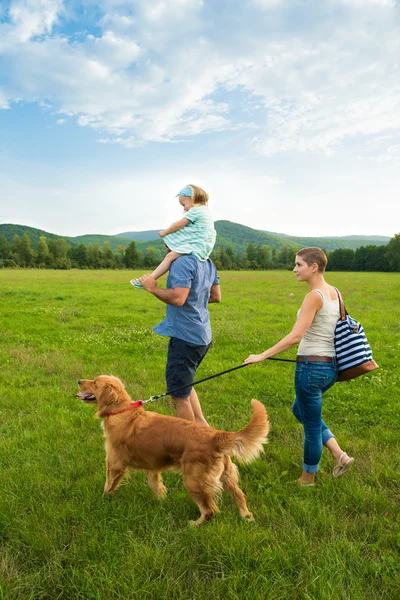 Keluarga muda yang cantik dengan anjing peliharaan mereka, golden retriever — Stok Foto