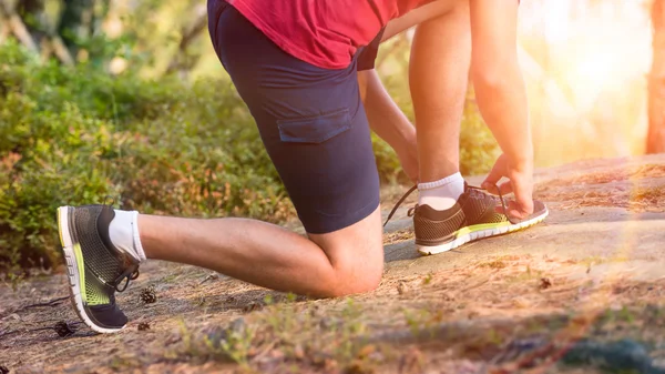 Jonge mannelijke atleet koppelverkoop zijn schoenen veters — Stockfoto