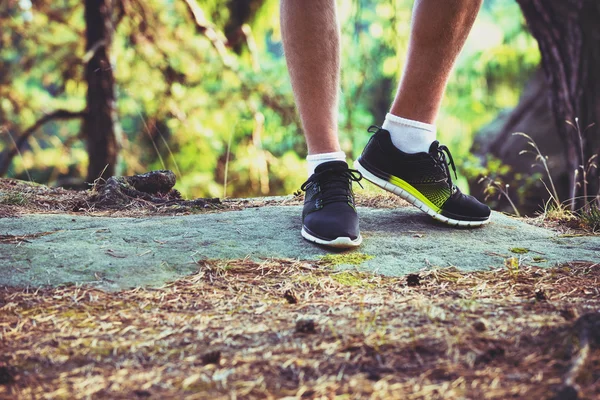 Jonge man kruis land runner, de benen en de schoenen detail — Stockfoto