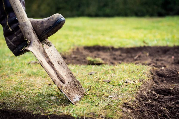 Hombre usando pala para la excavación de césped viejo — Foto de Stock