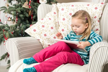 Noel ağacının yanında iskambil ile kız tablet Pc