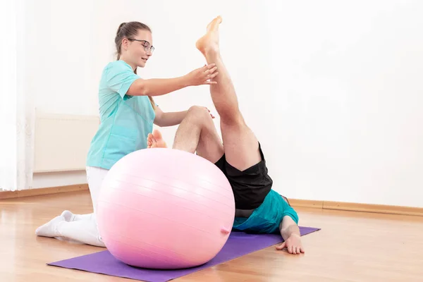 Physiotherapist Working Young Male Client Core Strength Using Fitball Rehabilitation — Stock Fotó