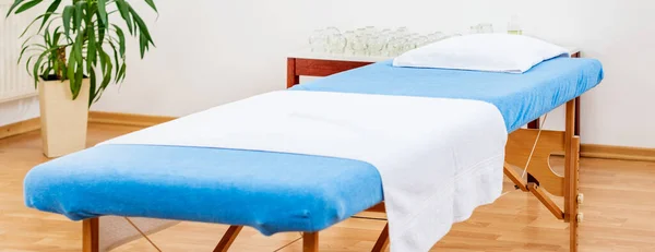 Interior of a medical treatment room with portable examination table. Vacuum cupping, massage or physical therapy background.