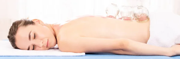 Woman Getting Vacuum Cupping Treatment At a Spa. Vacuum Cupping Therapy. Treatment used in Traditional Chinese Medicine for pain relief and other health benefits.