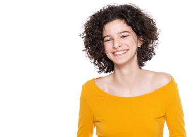 Beyaz arka planda kıvırcık saçlı, kendine güvenen genç bir kızın stüdyo portresi. Gülümseyen genç bir kızın stüdyo portresi. 