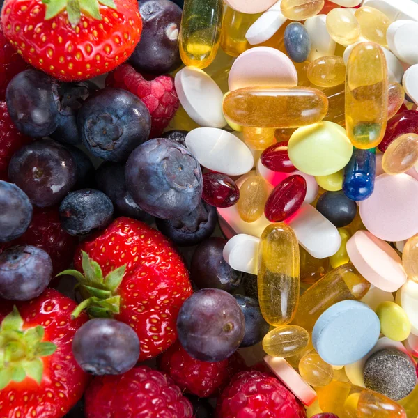 Здоровый образ жизни, концепция диеты, фрукты и таблетки, витаминные добавки на белом фоне — стоковое фото