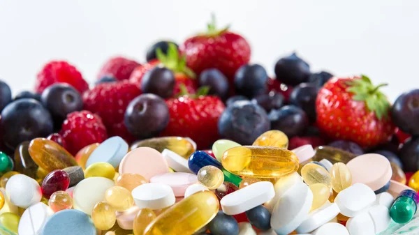 Sağlıklı yaşam, diyet kavramı, meyve ve hapları, vitamin ile beyaz arka plan üzerinde takviyeleri