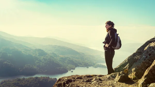 Female hiker on top of the mountain enjoying valley view, Ben A 'an, Loch Katrina, Highlands, Scotland, UK, insurance concept — стоковое фото