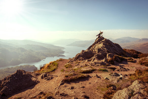 Two female hikers on top of the mountain enjoying valley view, Ben A 'an, Loch Katrina, Highlands, Scotland, UK
