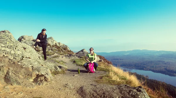 Two female hikers on top of the mountain taking a break and enjoying a valley view, Ben A'an, Loch Katrina, Highlands, Scotland, UK — Stock Photo, Image