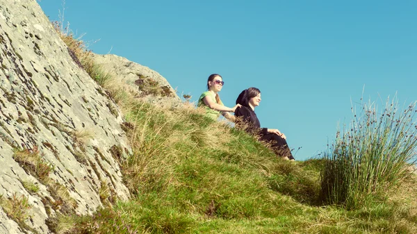 Zwei Wanderinnen auf dem Gipfel des Berges machen eine Pause und genießen einen Blick ins Tal, ben a 'an, loch katrina, Hochland, Schottland, uk — Stockfoto