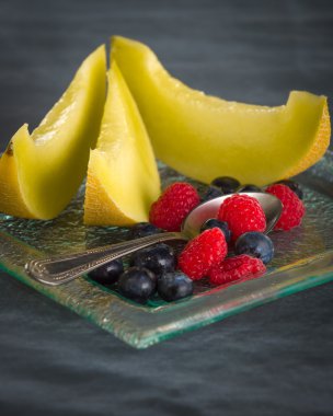 Siyah arka plan üzerine cam tatlı tabakta taze sağlıklı meyve