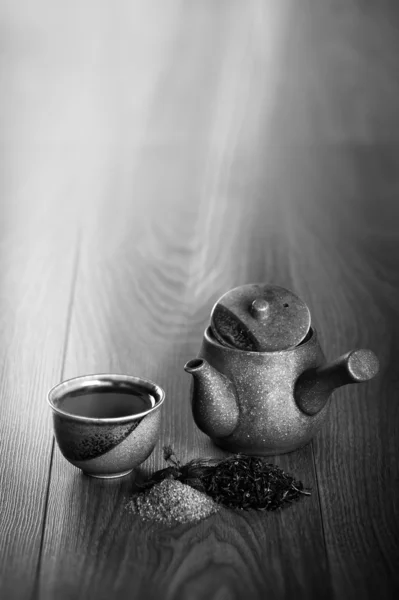 Ceramic teapot, cup of black tea with mint leaves and brown sugar on wooden table — Stock Photo, Image
