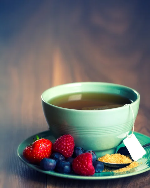 Cup of fruit tea with strawberries, raspberries and blueberries — Stock Photo, Image