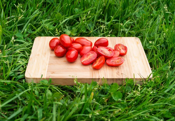 Tomates cerises fraîches sur la vieille planche à découper en bois, gros plan sur la nourriture, en plein air — Photo