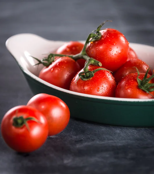 Mogna körsbär tomater i en skål på svart bakgrund — Stockfoto