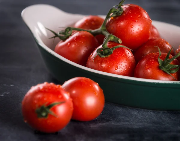 Mogna körsbär tomater i en skål på svart bakgrund — Stockfoto