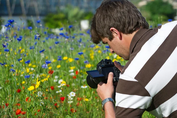 Young handsome caucasian photographer, videographer in botanic gardens — Stock Photo, Image