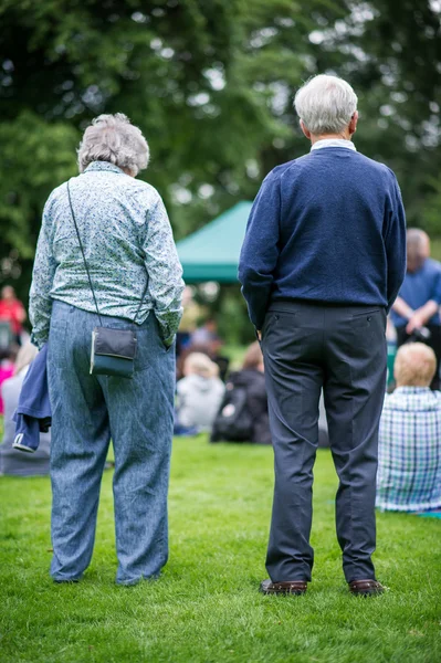 Older generation, seniors, enjoying an outdoors music, culture, community event, festival. — Stock Photo, Image