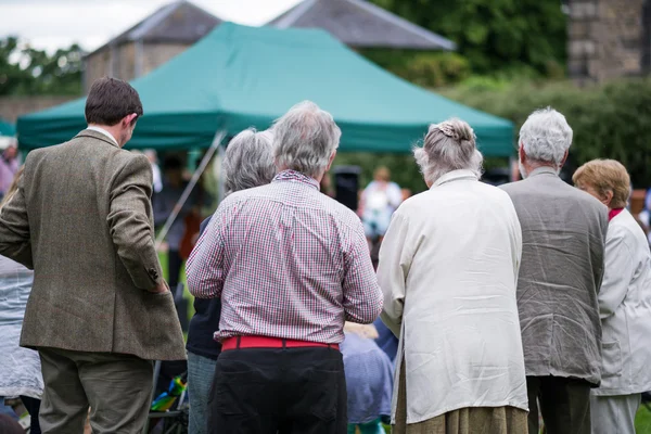 Older generation, seniors, enjoying an outdoors music, culture, community event, festival. — Stock Photo, Image