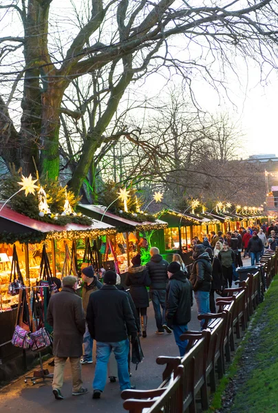 EDINBURGH, SCOTLAND, UK, December 08, 2014 - People walking among german christmas market stalls in Edinburgh, Scotland, UK, with Edinburgh castle in the background — Stock Photo, Image