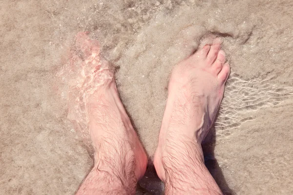 Maschio piedi nudi in una sabbia calda su una spiaggia soleggiata durante le vacanze — Foto Stock